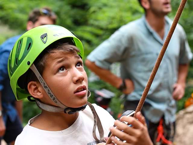 Garçon de 10 ans faisant de l'escalade en colonie de vacances