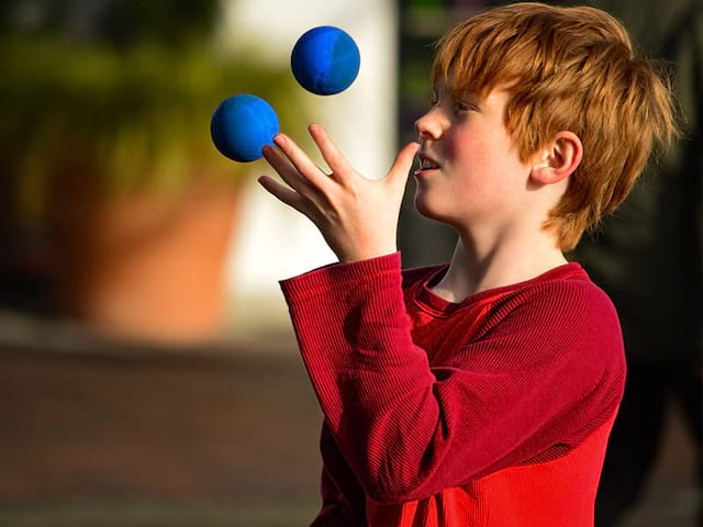 enfant jonglant avec des balles en colonie de vacances cirque