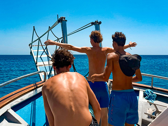 Groupe de jeunes sur un bateau en colo de vacances à Minorque en Espagne qui profitent de leur colo