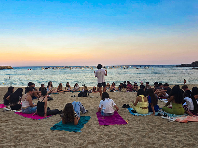 Groupe de jeunes à la plage qui profitent de leur colo à Barcelone ce printemps
