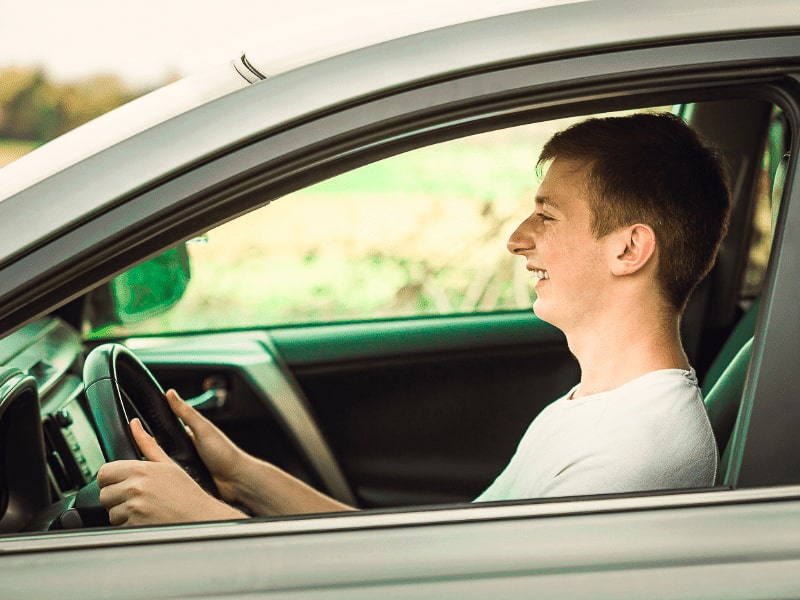 Jeune garçon heureux de conduire en colonie de vacances Conduite accompagnée préparant les examens de conduite 