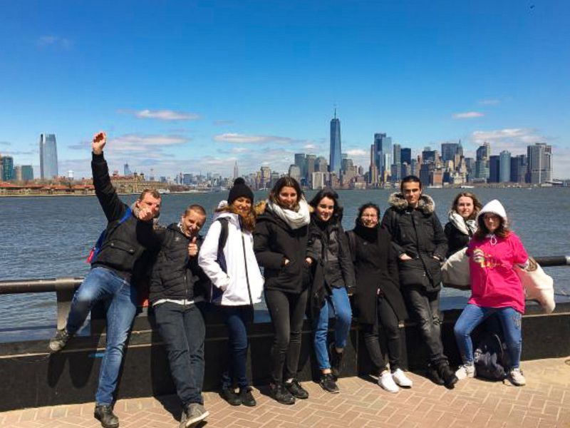 Groupe d'ados qui posent devant la skyline en colo de vacances à New York