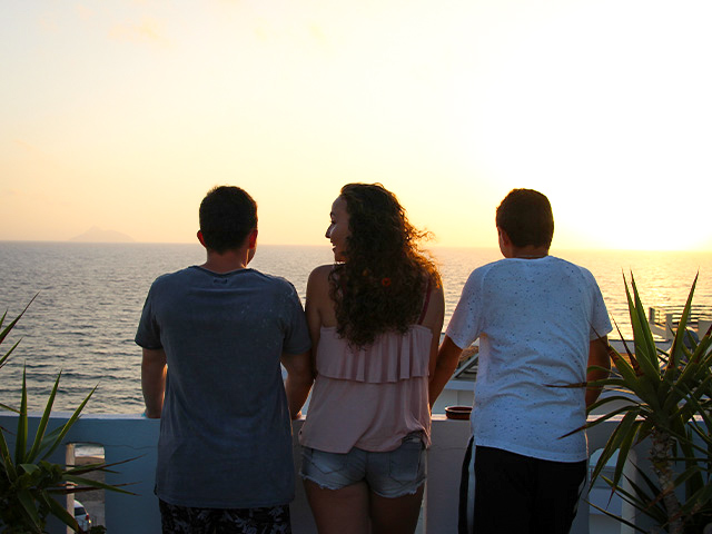 trois jeunes devant un coucher de soleil en grece 