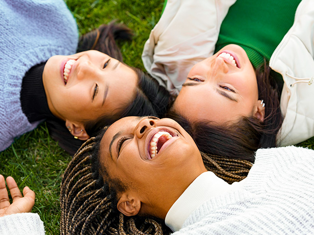 filles rigolant allongees sur l'herbe colo de vacances