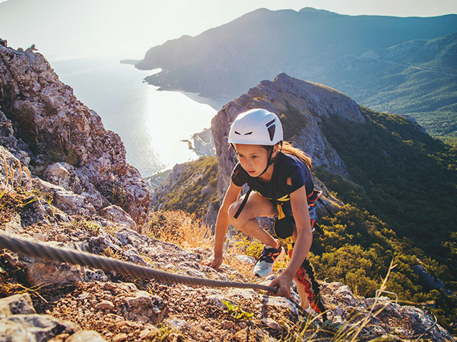 jeune fille montant une montagne avec son baudrier via ferrata hautes alpes printemps