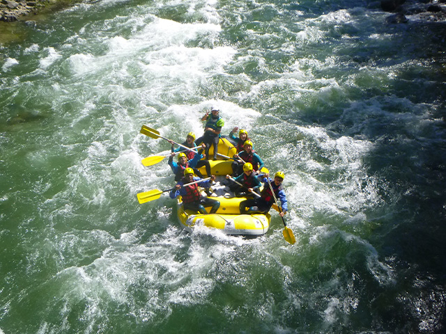 groupe d'adolescents faisant du rafting dans les courants hauts alpins au printemps