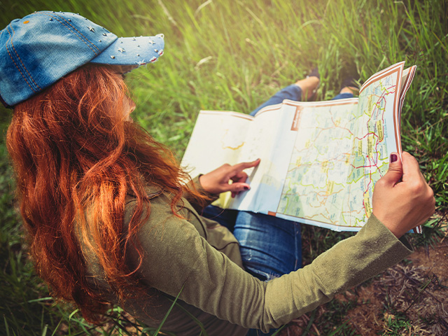 jeune fille avec sa carte participant a une course d'orientation durant colonie de vacances a la montagne au mois d'avril