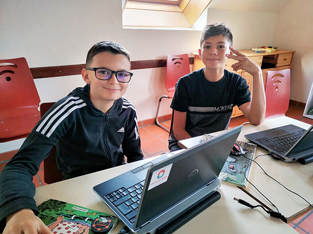 deux jeunes sur leurs ordinateurs colonie de vacances codage et programmation paques