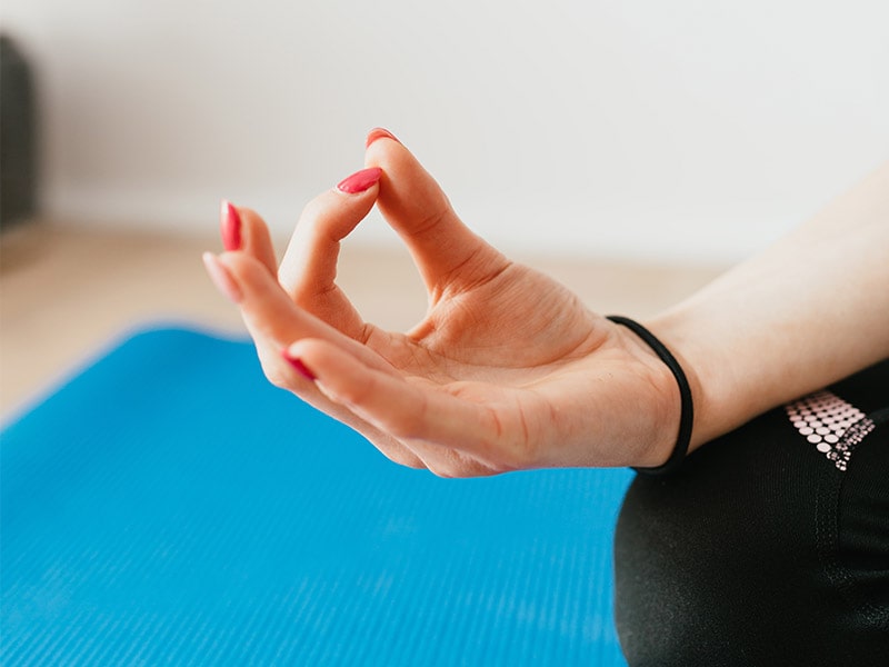 Gros plan sur des doigts rapprochés en position zen et yoga lors d'une colonie de vacances durant le printemps