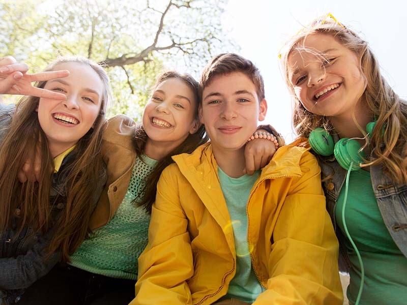 Vue sur un groupe de jeunes ados qui sourient lors d'une colo de vacances Corps et Esprit durant le printemps
