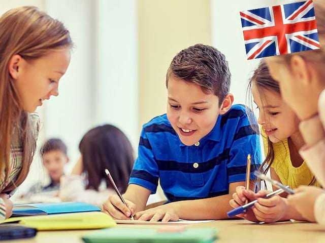 Groupe d'enfants apprenant l'anglais ensemble en colonie de vacances