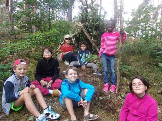 Groupe d'enfants face à leur cabane construite en colo