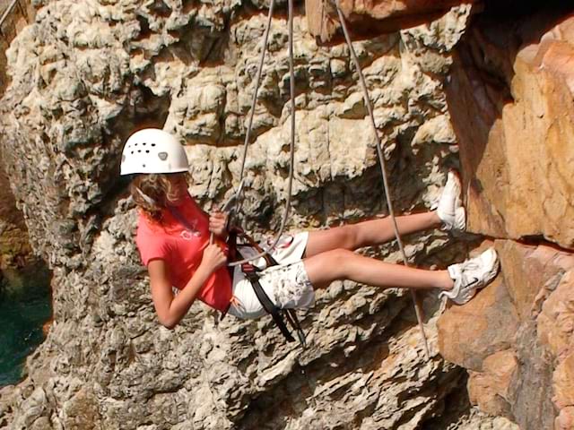 Enfant descend en rappel durant l'escalade