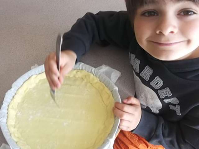 Jeune garçon préparant la pâte à tarte