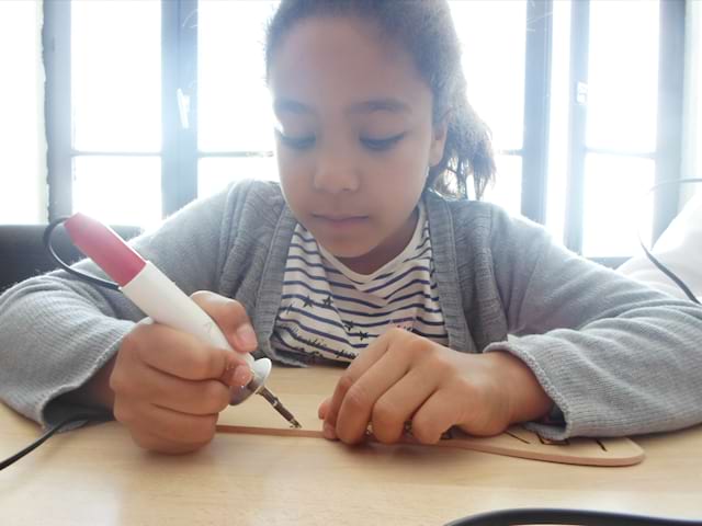 Enfant apprenant la pyrogravure