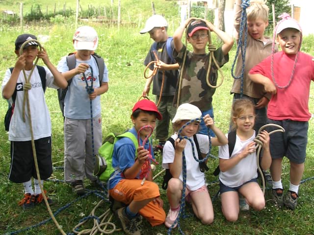 Groupe d'enfants en colo apprenant à faire un noeud