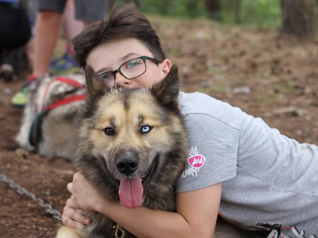 Portrait d'un enfant avec son chien en cani-rando