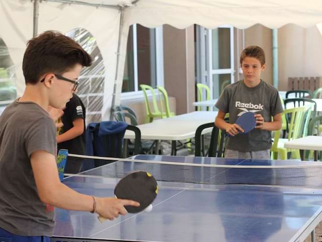 Enfants jouant au tennis de table en colo