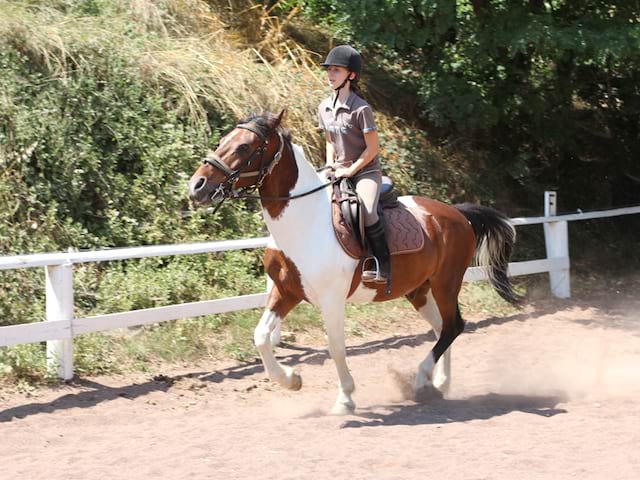 Jeune fille en balade à cheval en colo