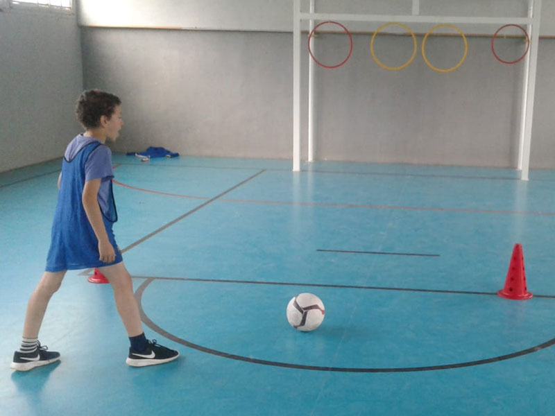 Enfant apprenant à marquer un but au football 
