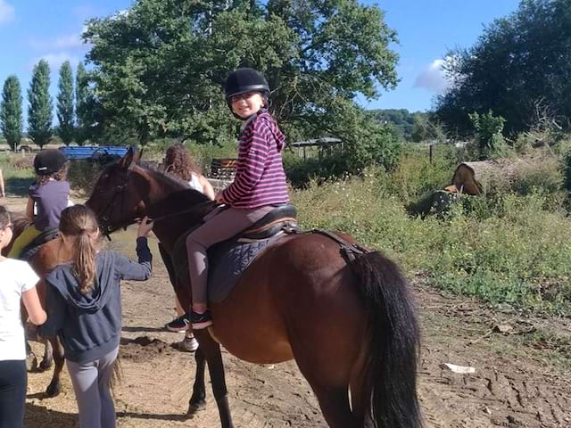 Enfants pratiquant l'équitation en colonie de vacances