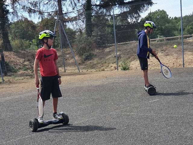 Enfants pratiquant le tennis en hoverboard en colonie de vacances