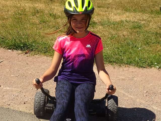 Jeune fille apprenant à utiliser un hover kart en colo