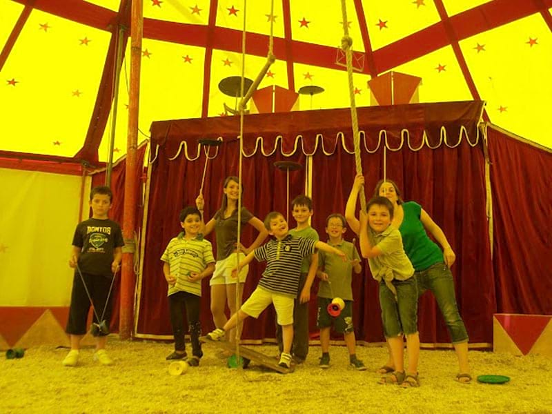 Enfants sous un chapiteau de cirque en colonie de vacances