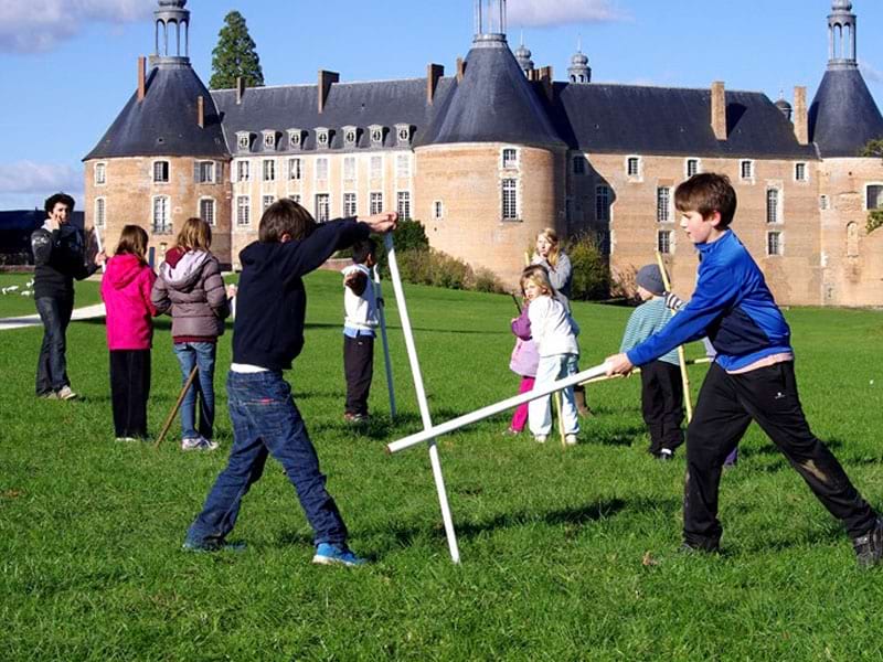 Enfants jouant avec des épées en bois en colonie de vacances 