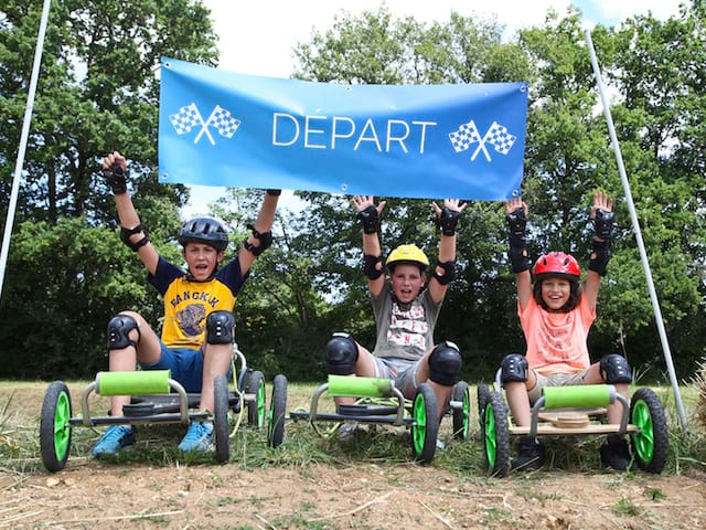 Enfants qui font une course de kart en colonie de vacances