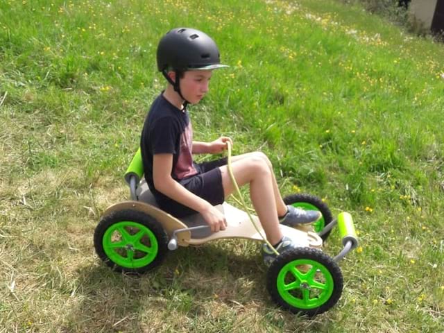 Enfant sur une luge à roulette en colo 