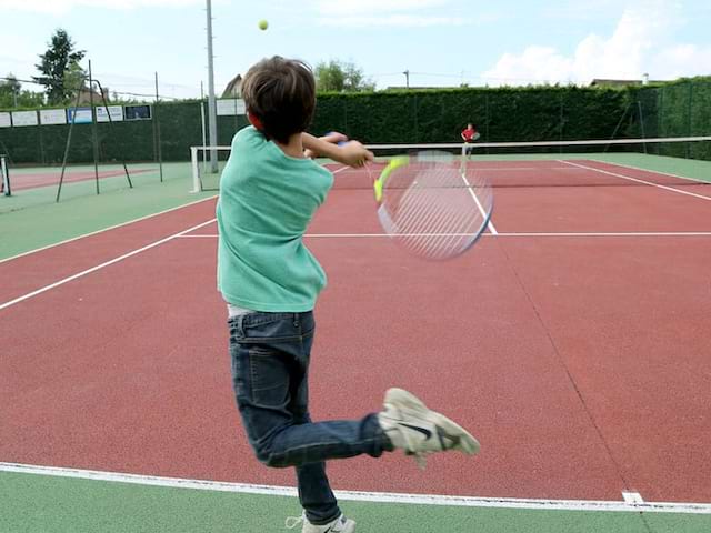 Enfant jouant au tennis en colonie de vacances