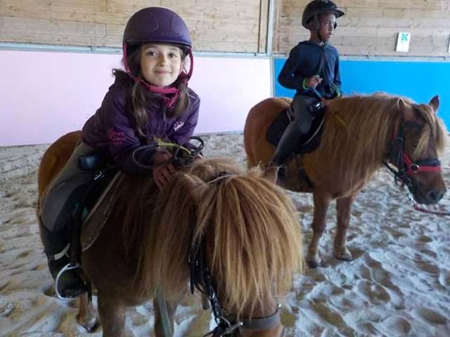 Enfants avec des poneys en colonie de vacances