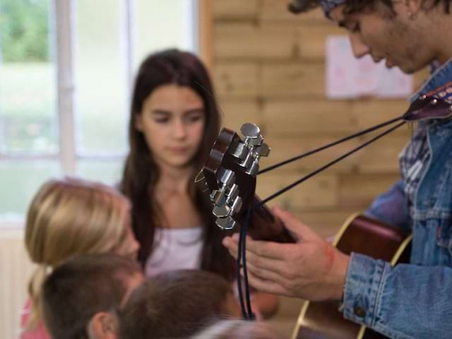 Animateur de colonie de vacances jouant de la guitare