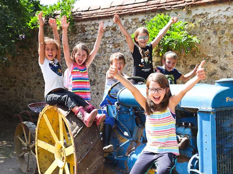 Enfants à la ferme en colo sur un tracteur