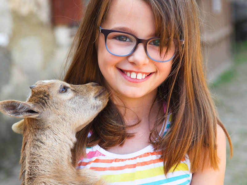 portrait d'une enfant de 8 ans avec une chèvre en colo