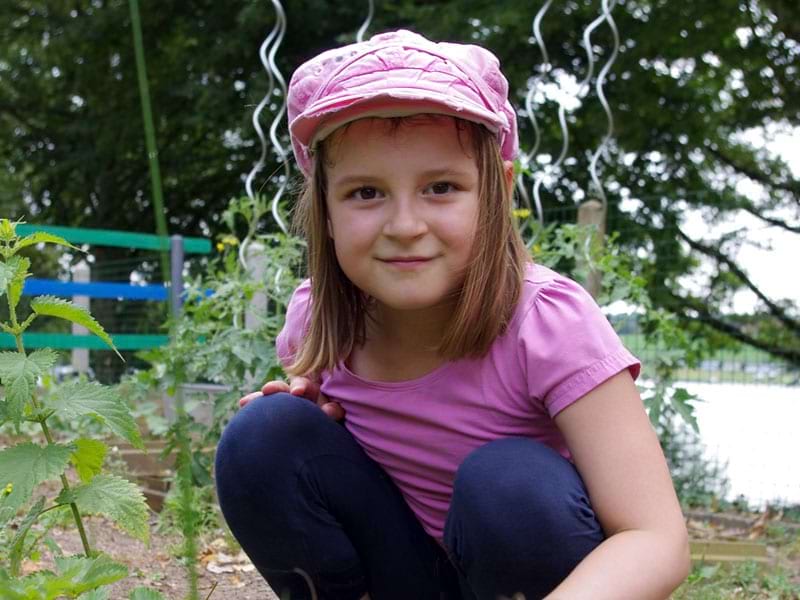 Enfant en colonie de vacances apprenant à jardiner