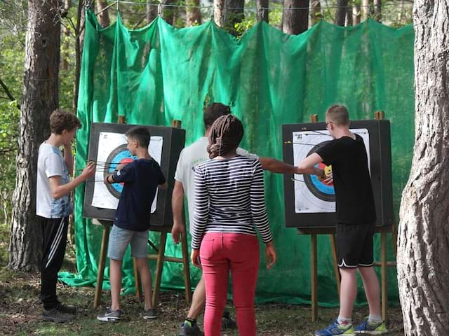 Enfants et adolescents découvrant le tir à l'arc cet automne en colonie de vacances