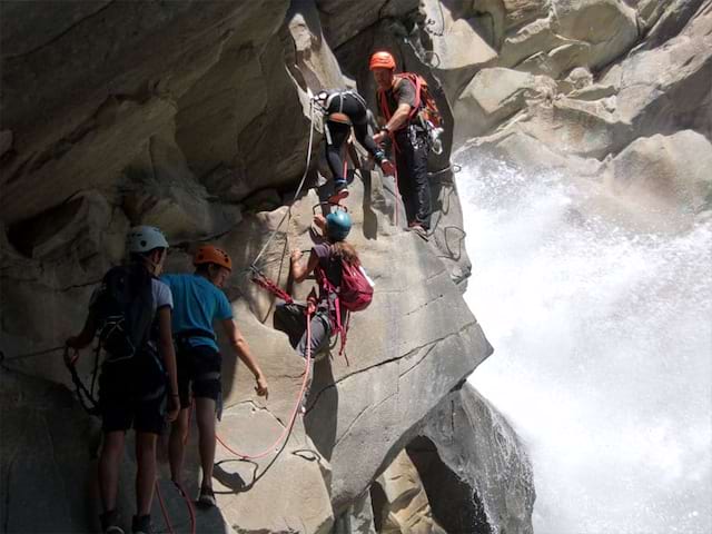 groupe d'adolescents découvrant la via ferrata en colo à la montagne cet automne