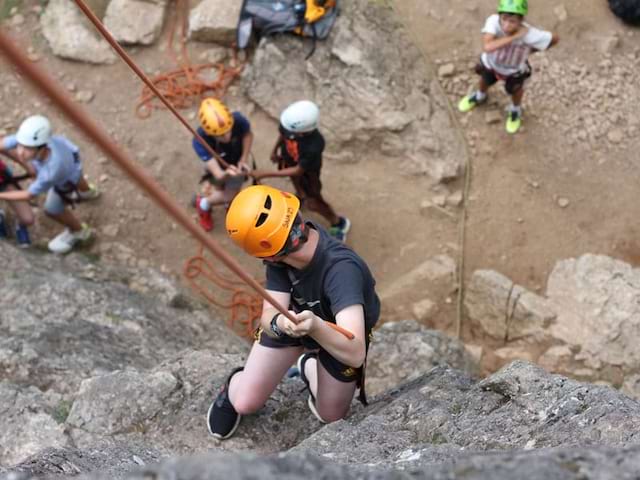 Ado faisant de la descente en rappel cet automne en colonie de vacances à la montagne