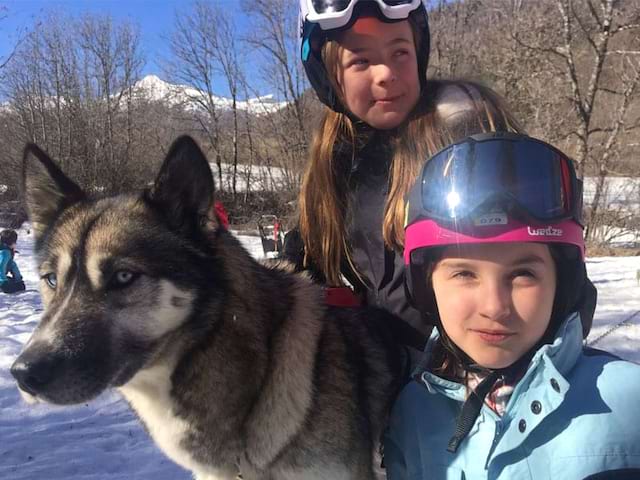 portrait de fillettes avec leur chien de traineau en colonie de vacances cet hiver