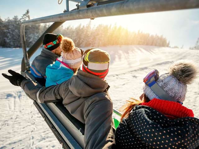 adolescents sur un télésiège en colonie de vacances à la montagne cet hiver