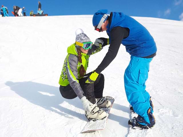 ado apprenant à faire du snowboard cet hiver en colonie de vacances