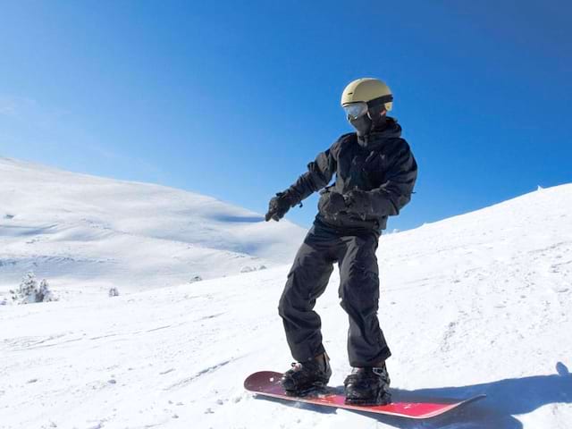 ado à snowboard en colo sur les pistes de ski 