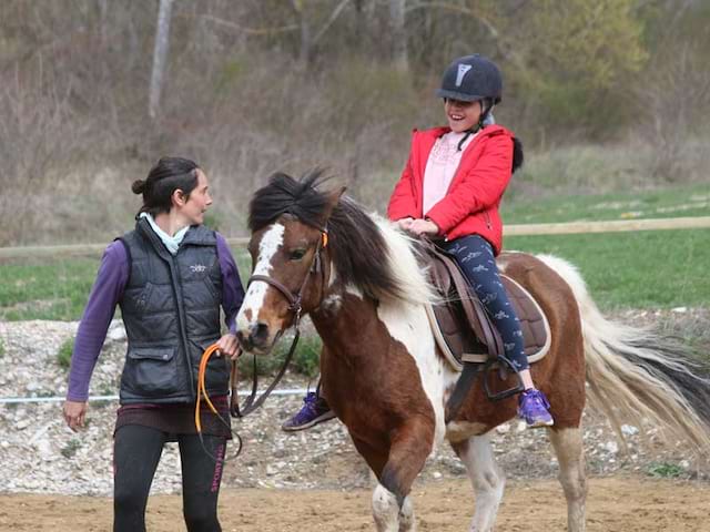 ados en colonie de vacances apprenant à monter à cheval