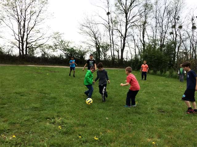 Groupe d'enfants jouant au football cet automne en colonie de vacances