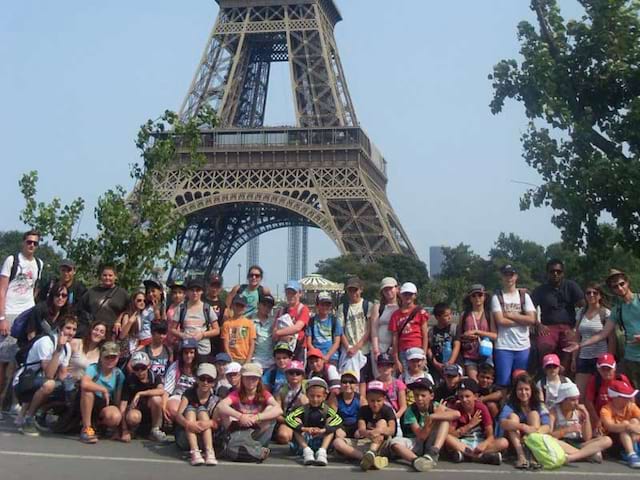 Groupe d'ados au pied de la tour Eiffel en colo à Paris