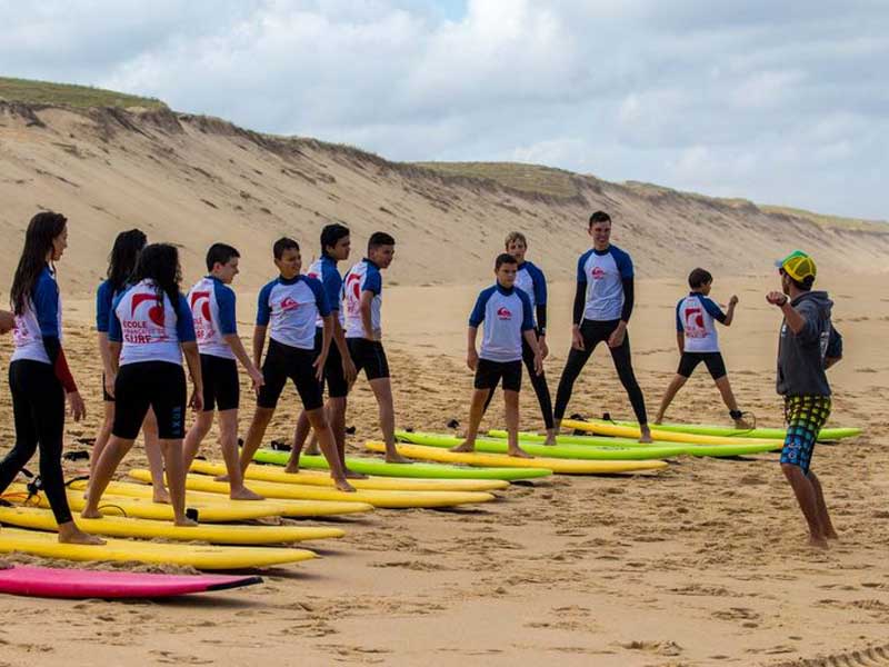 Groupe d'adolescents sur les planches de surf en colo cet automne