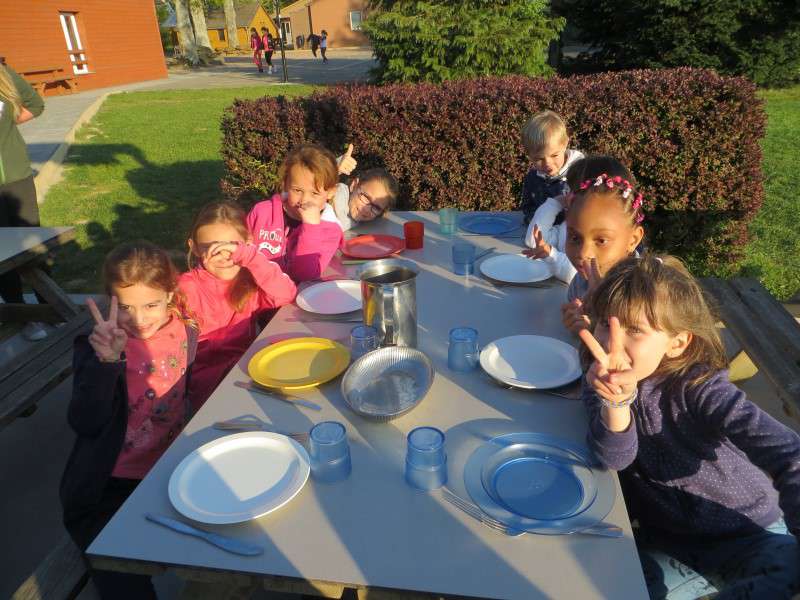 Enfants mangeant dehors en colo à la campagne