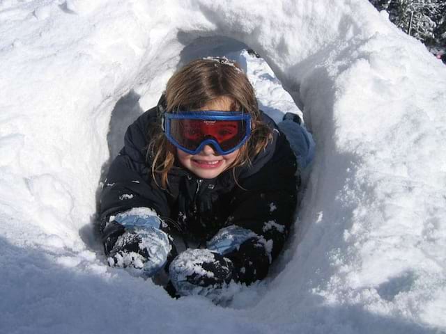 fillette s'amusant dans la neige cet hiver en colonie de vacances